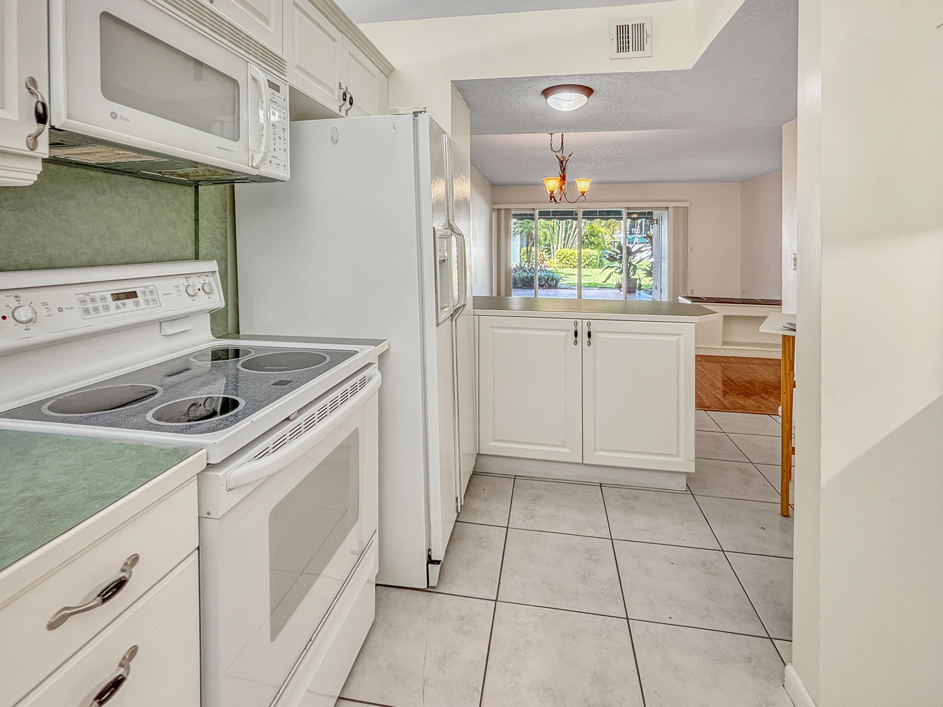 390 Golfview Road, Unit G North Palm Beach, FL 33408 - Photo 7 of 36 a kitchen with a stove a sink and a refrigerator