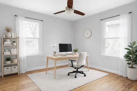 a view of a workspace with furniture and a window