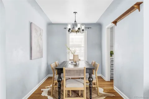a dining room with furniture a chandelier and window