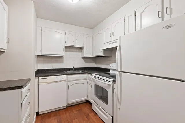 a kitchen with white cabinets and white appliances