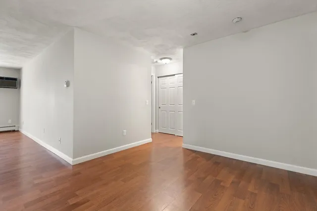 a view of an empty room with wooden floor
