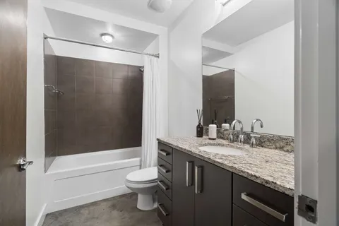 a bathroom with a granite countertop sink toilet and shower