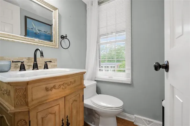 a bathroom with a sink a toilet and a mirror