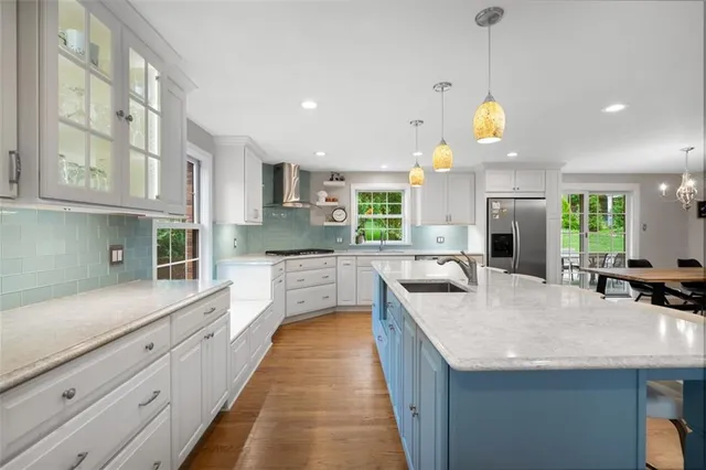 a large kitchen with granite countertop a large counter top appliances and cabinets