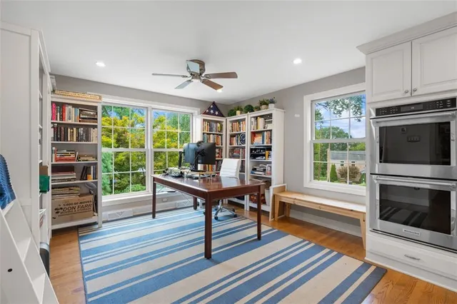 a living room with furniture a flat screen tv and a floor to ceiling window