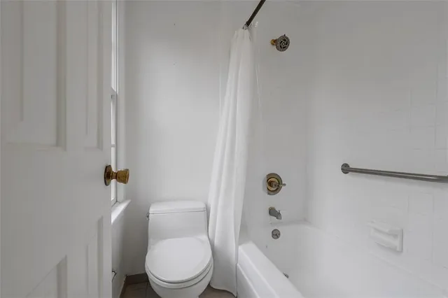 a white toilet sitting next to a bath tub