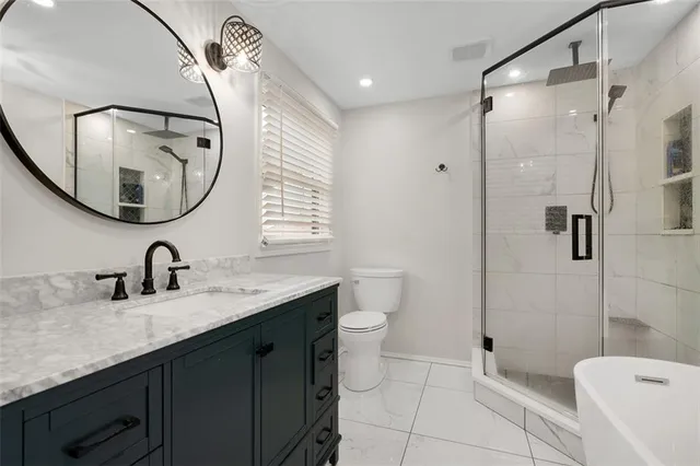 a bathroom with a granite countertop sink a toilet and a mirror