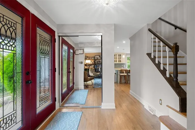 a view of a hallway with wooden floor and staircase