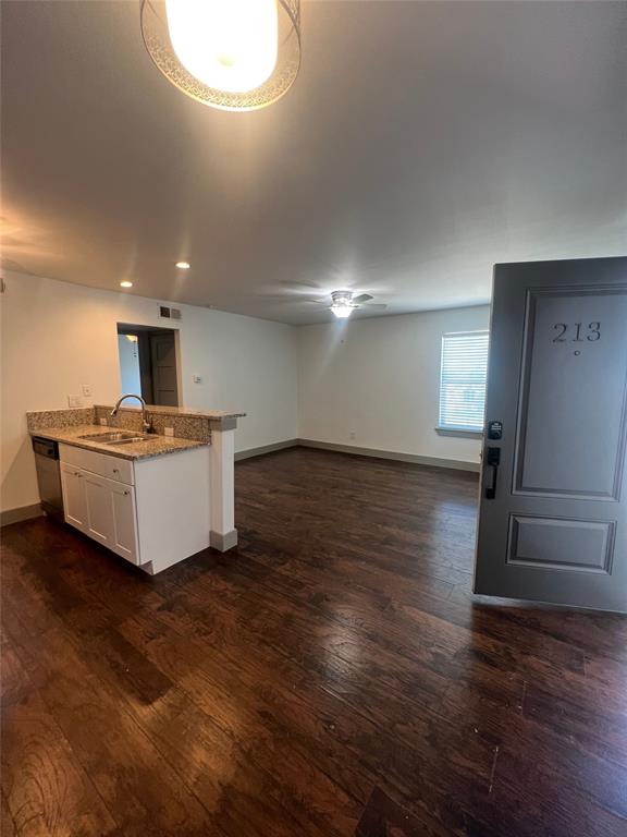 4633 Fairmount Street, Unit 213 Dallas, TX 75219 - Photo 9 of 9 Kitchen featuring light stone counters, dark wood-style flooring, a peninsula, open floor plan, and recessed lighting