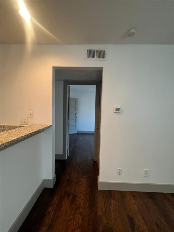 4633 Fairmount Street, Unit 213 Dallas, TX 75219 - Photo 4 of 9 Corridor with dark wood finished floors and baseboards