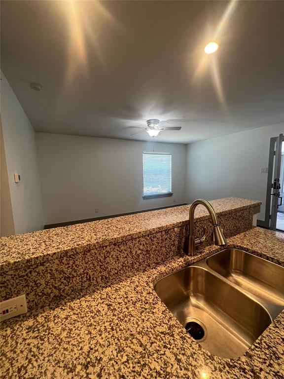 4633 Fairmount Street, Unit 213 Dallas, TX 75219 - Photo 5 of 9 Kitchen view of dark stone countertops and ceiling fan