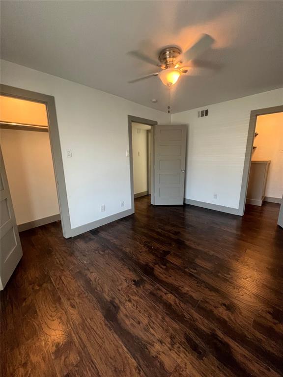 4633 Fairmount Street, Unit 213 Dallas, TX 75219 - Photo 6 of 9 Unfurnished bedroom with ceiling fan, dark wood finished floors, and a closet