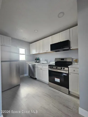 a kitchen with stainless steel appliances a stove a sink and a refrigerator