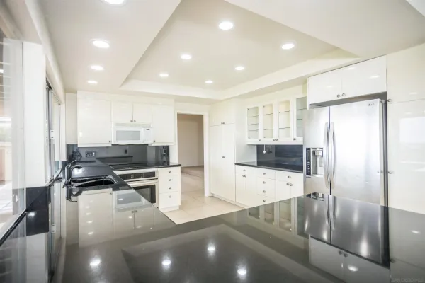 a large white kitchen with cabinets