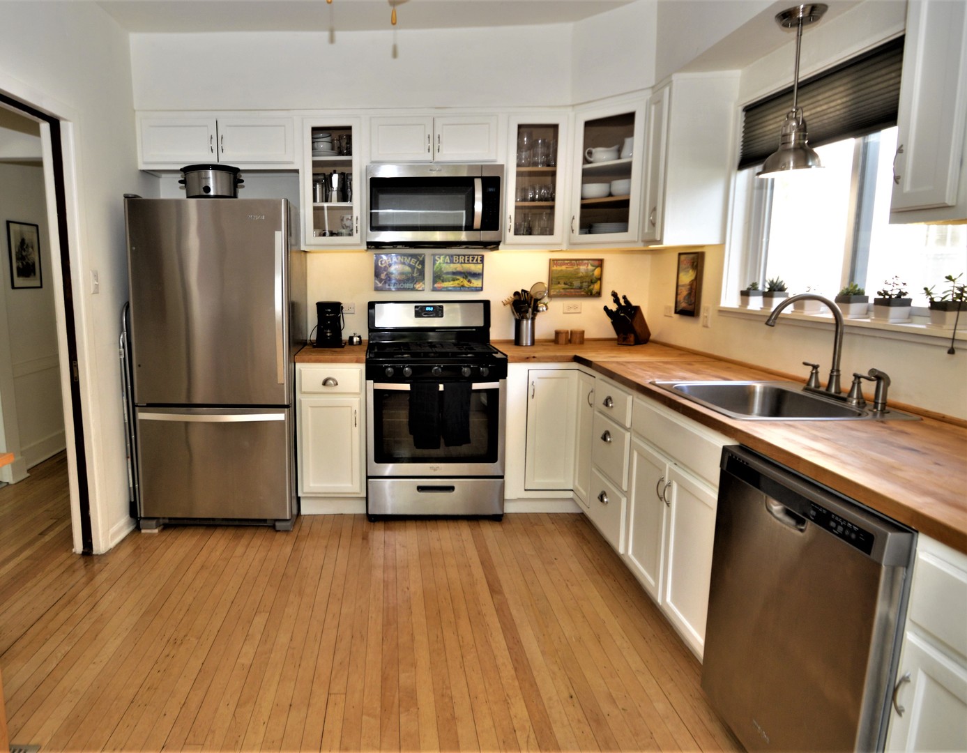 111 Groveland Avenue Riverside, IL 60546 - Photo 8 of 40 a kitchen with stainless steel appliances a refrigerator a sink a stove a microwave and wooden floors