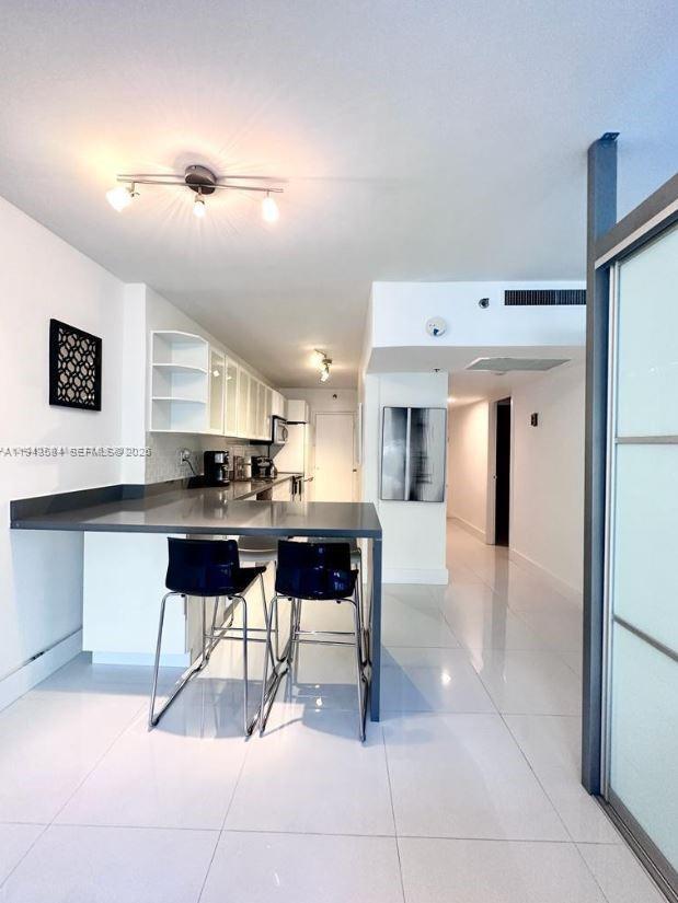 100 Lincoln Road, Unit 526 Miami Beach, FL 33139 - Photo 12 of 19 a open kitchen with stainless steel appliances kitchen island granite countertop a sink and cabinets