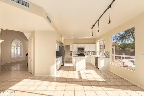 a view of a living room with kitchen view and appliances