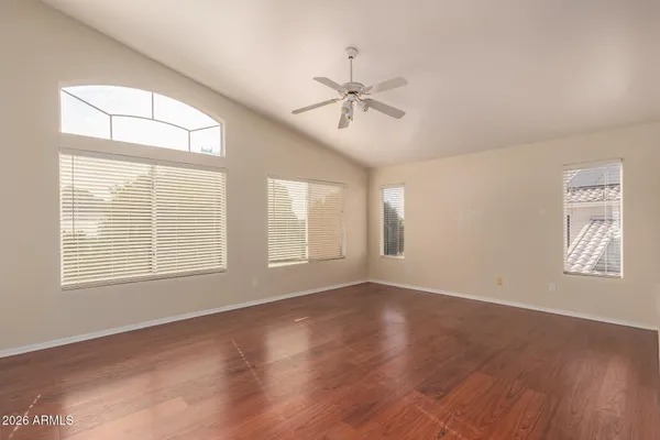 a view of an empty room with a window and wooden floor