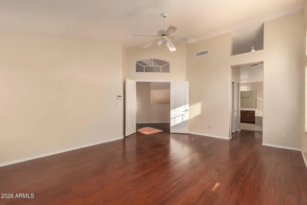 a view of an empty room with wooden floor and white walls