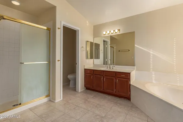 a spacious bathroom with a granite countertop sink mirror and a bathtub