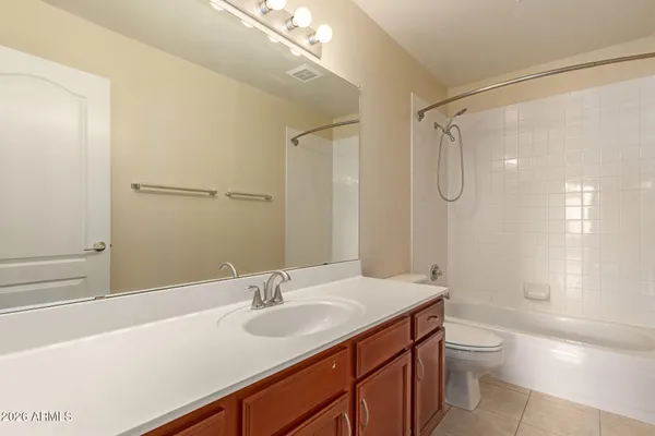 a bathroom with a granite countertop sink a toilet and shower