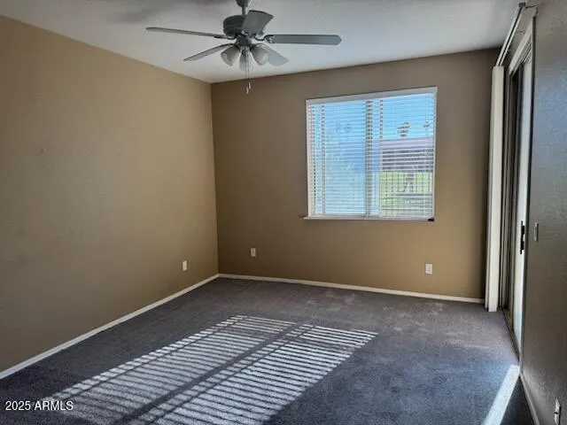 an empty room with windows and fan