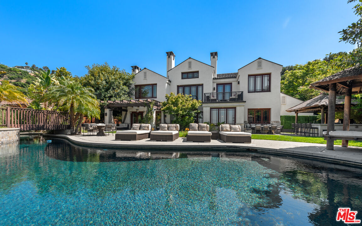 a front view of a house with swimming pool having outdoor seating