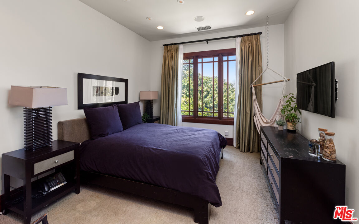 13947 Durham Road Beverly Hills, CA 90210 - Photo 13 of 15 a bedroom with a bed and a flat tv screen on a dresser