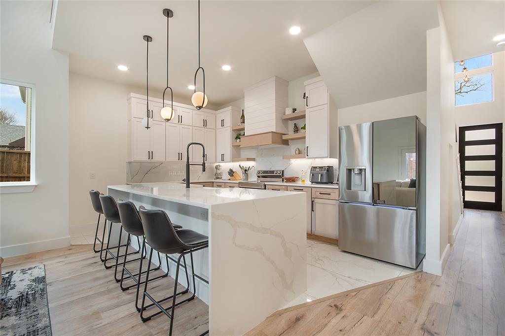 4648 Corregidor Street Dallas, TX 75216 - Photo 8 of 30 a kitchen with stainless steel appliances granite countertop a sink a stove a refrigerator and island with wooden floor