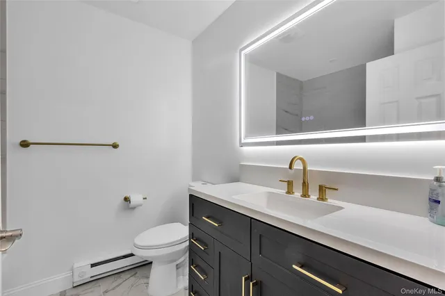 a bathroom with a sink a toilet and mirror