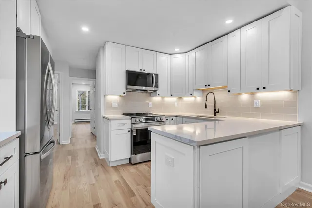 a kitchen with kitchen island granite countertop a sink stainless steel appliances and counter space