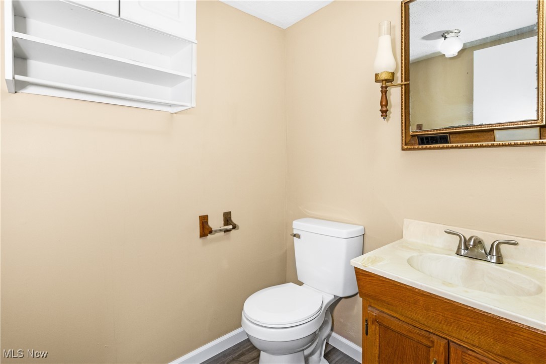 7529 State Line Burghill, OH 44404 - Photo 13 of 23 Half bath featuring vanity and dark wood-style flooring