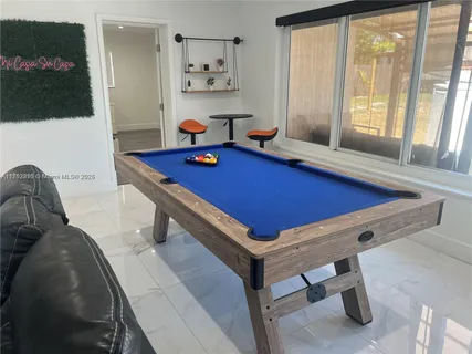 a room with pool table and windows