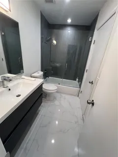 a bathroom with a double vanity sink toilet and shower