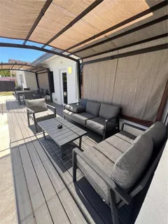 a view of a patio with couches and a table and chairs with wooden floor