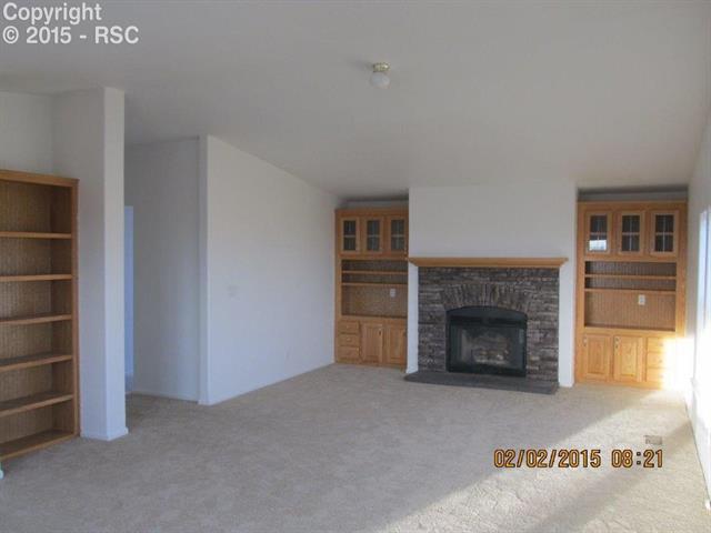 21376 County Road South, Unit 2 Rush, CO 80833 - Photo 8 of 17 The family room has bookcases and a cozy fireplace to keep you toasty warm while you relax after work.