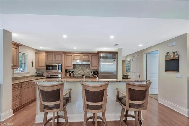 a kitchen with a sink and chairs