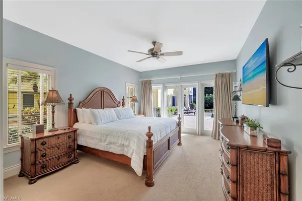 a bedroom with a bed a chandelier and dresser