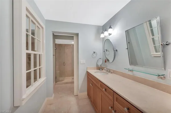 a bathroom with a double vanity sink mirror and shower