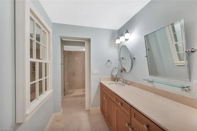 a bathroom with a double vanity sink mirror and shower