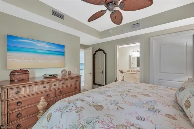 a bedroom with a bed and closet with mirror