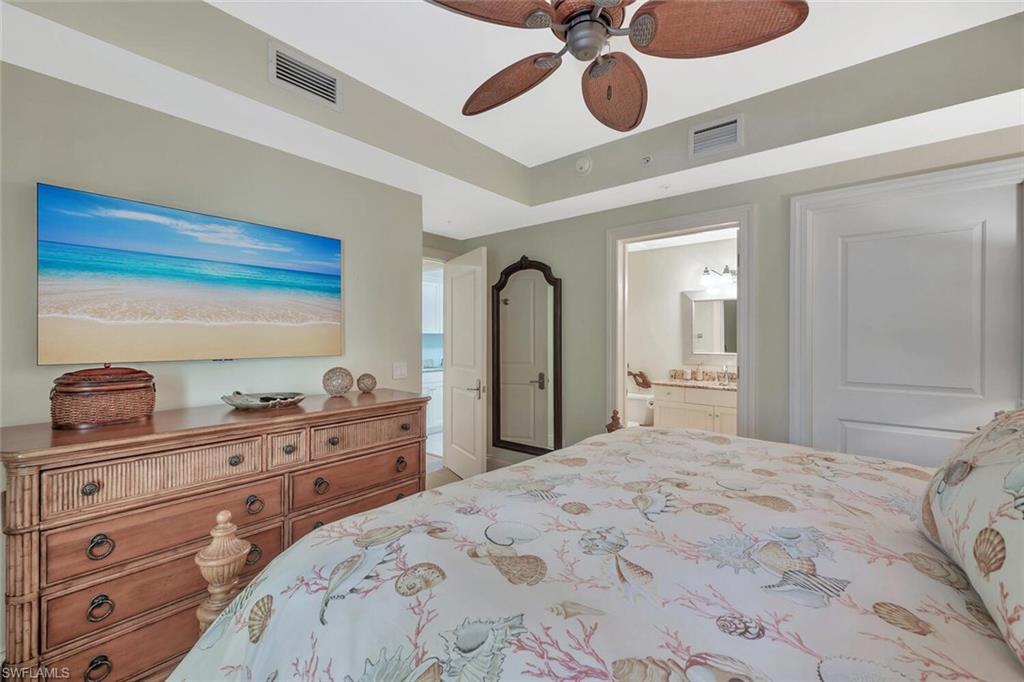 325 3rd Street South, Unit 6 Naples, FL 34102 - Photo 23 of 36 a bedroom with a bed and closet with mirror