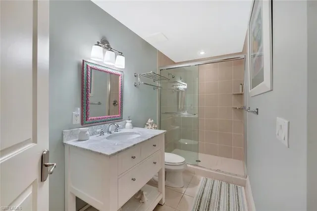 a bathroom with a sink a toilet a mirror and shower