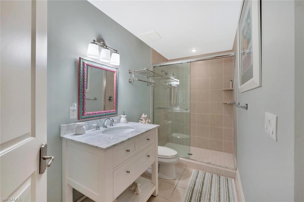 325 3rd Street South, Unit 6 Naples, FL 34102 - Photo 26 of 36 a bathroom with a sink a toilet a mirror and shower