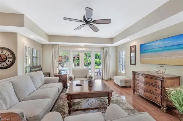 a living room with furniture a large window and a chandelier