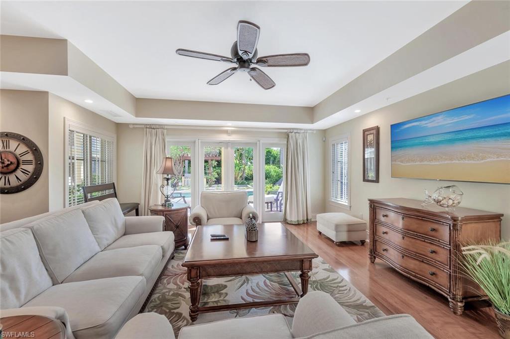 325 3rd Street South, Unit 6 Naples, FL 34102 - Photo 6 of 36 a living room with furniture a large window and a chandelier