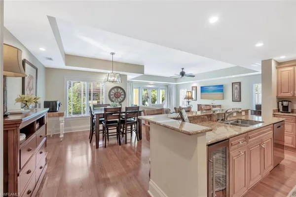 a view of a kitchen counter space dining table wooden floor and stainless steel appliances