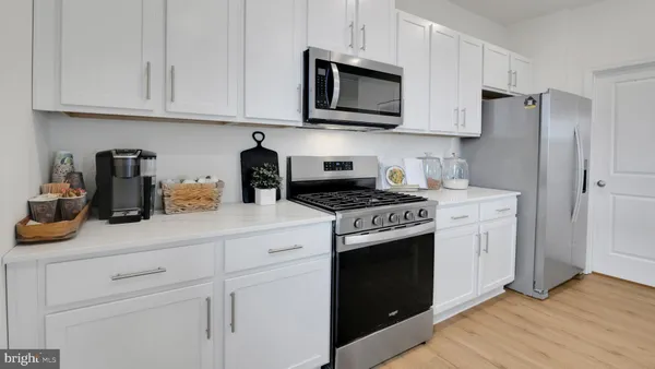 a kitchen with stainless steel appliances granite countertop white cabinets sink and a granite counter tops