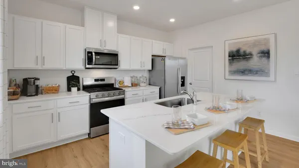 a kitchen with stainless steel appliances kitchen island granite countertop a sink a stove a dining table and chairs