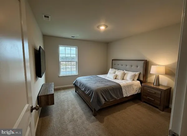 a bed room with a bed tv and a window